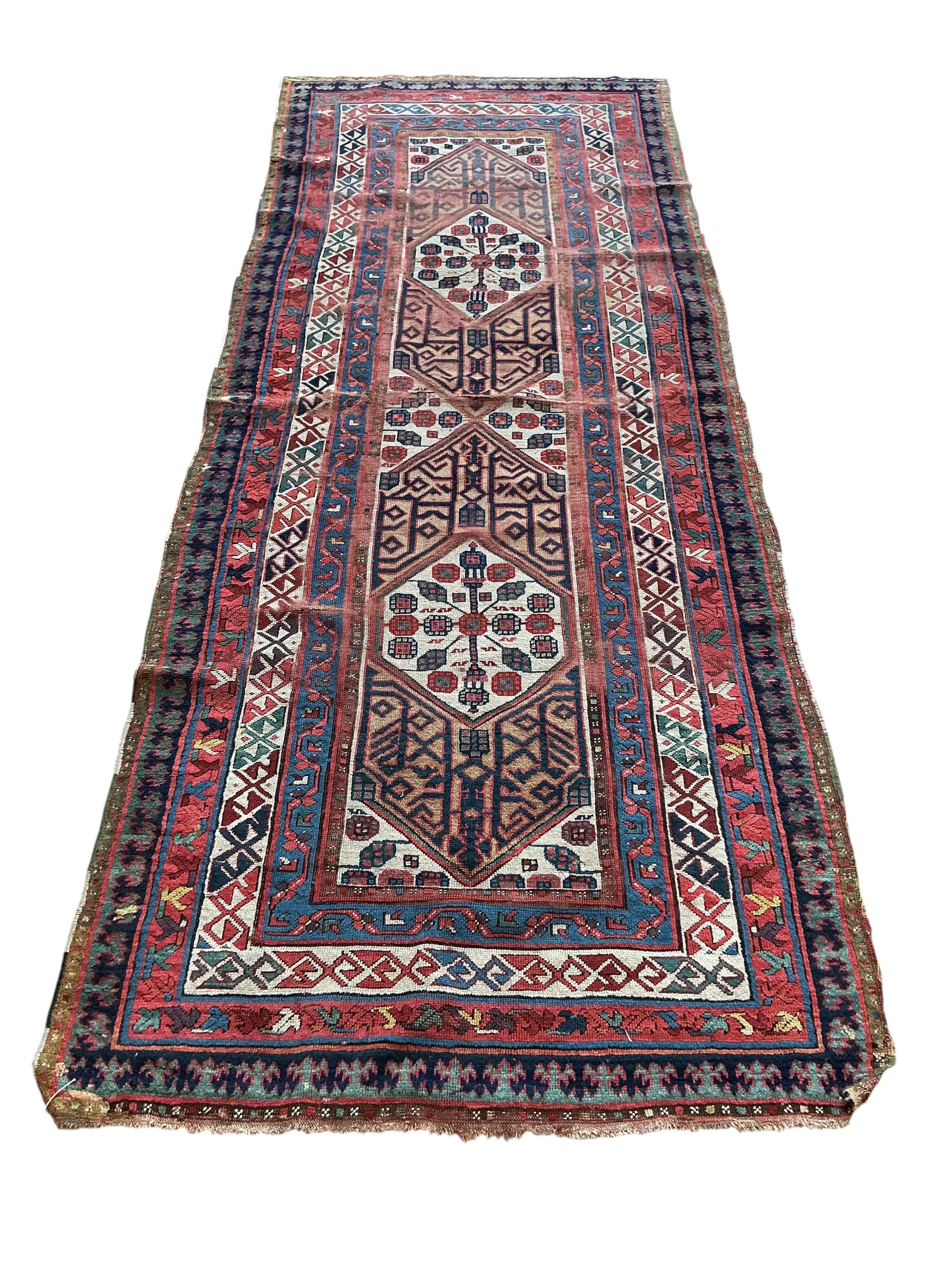 An antique Caucasian red ground runner, 260 x 102cm